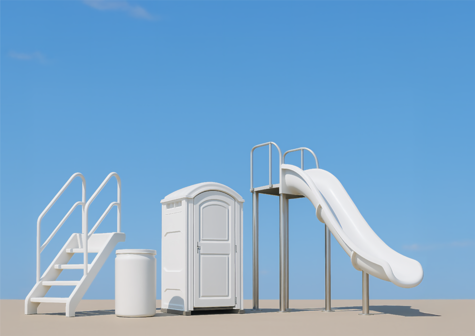 Das Bild zeigt eine weiße Rutsche und einer Treppe. Daneben stehen ein mobiles Toilettenhäuschen und ein Behälter, im Hintergrund ist ein klarer blauer Himmel zu sehen.